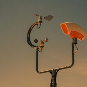 Weather monitoring equipment with a sunset sky backdrop, highlighting technology and atmosphere.